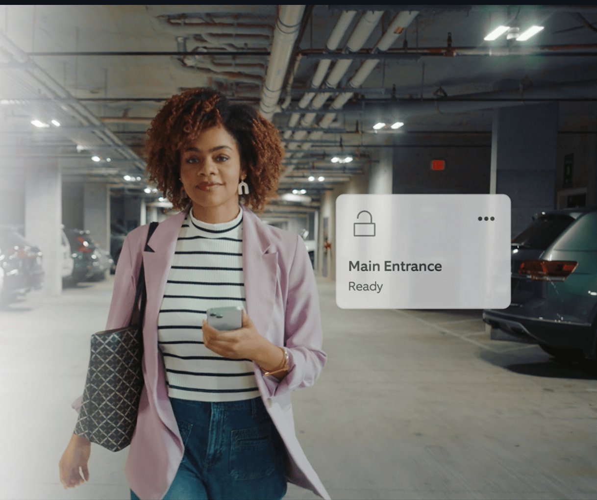Resident with phone in a parking garage, Main Entrance ready