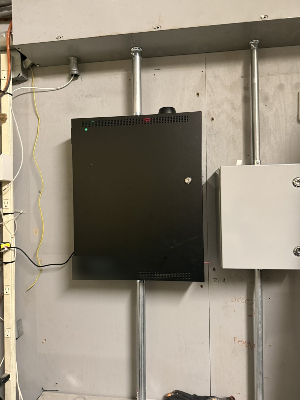 Controller enclosure and junction box on a utility room wall