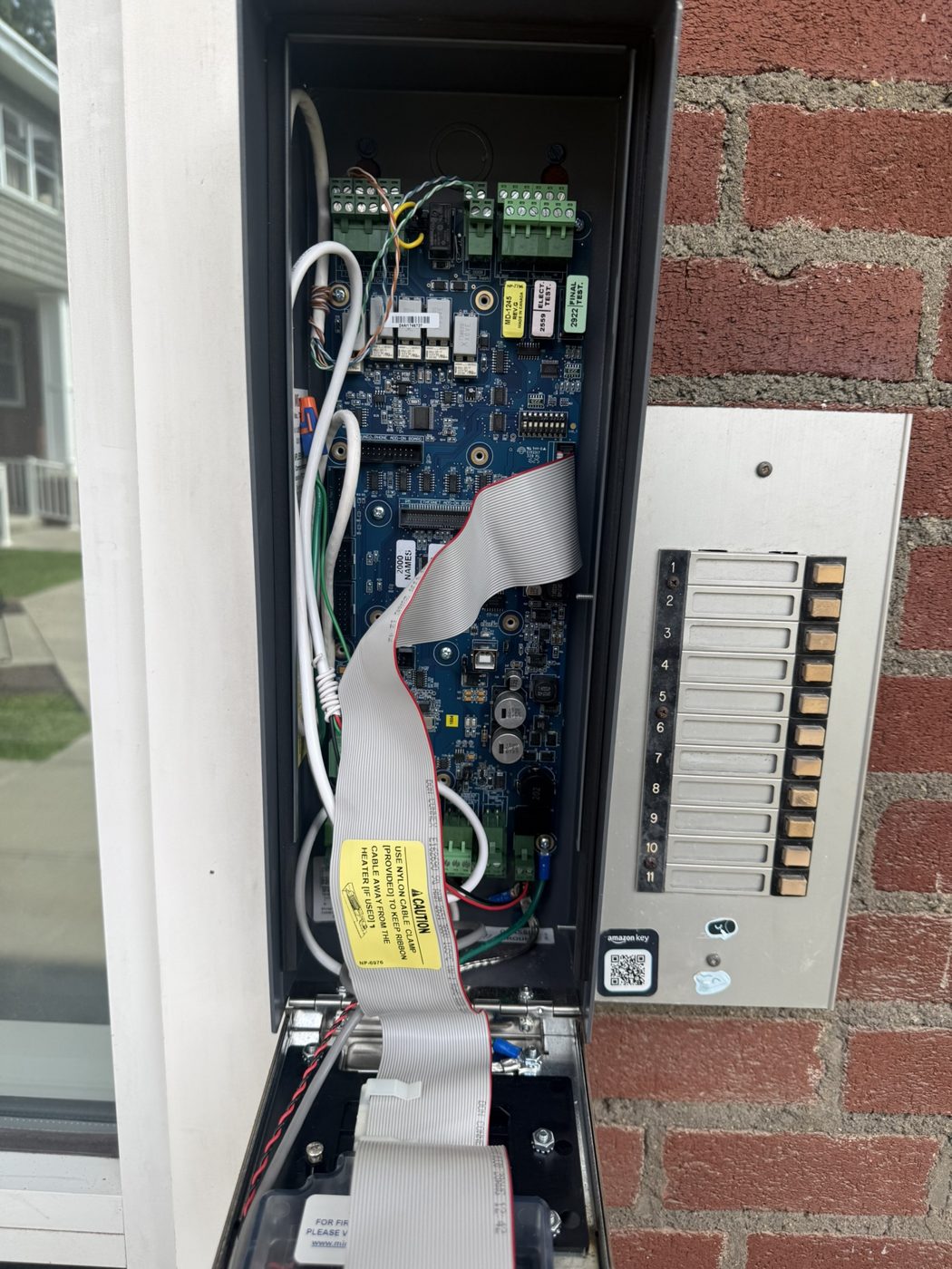Entry panel opened with circuit boards exposed, next to a directory